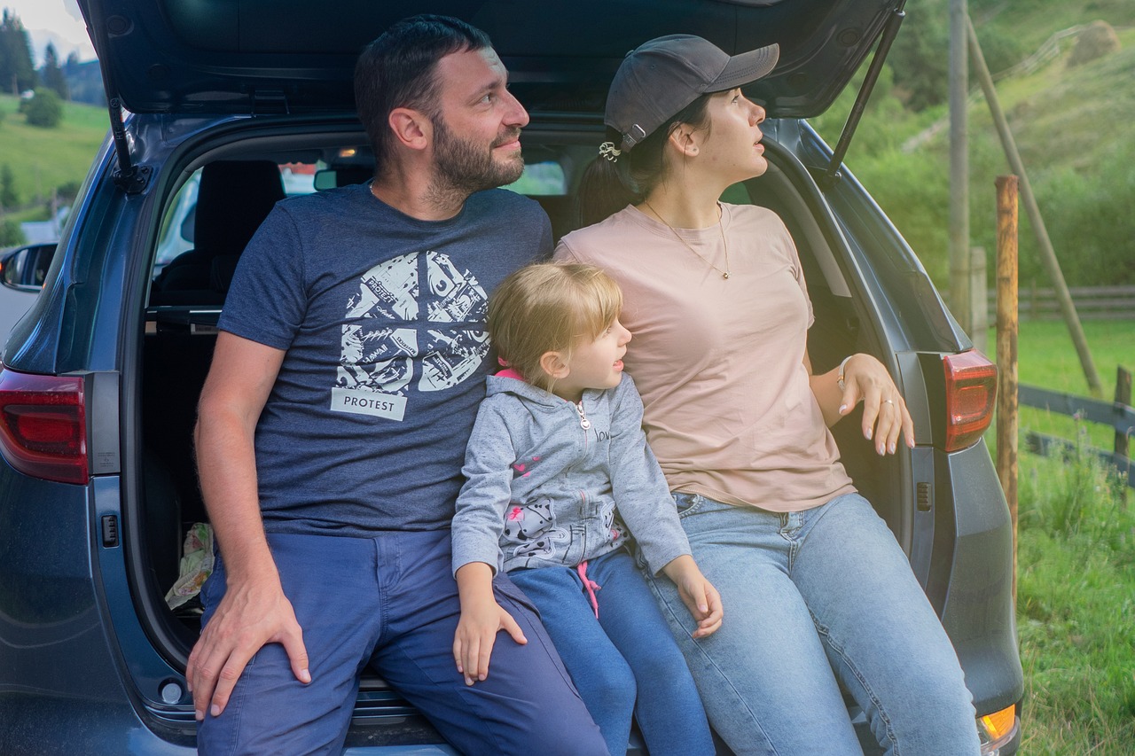 Family sitting at the back of a car during a road trip